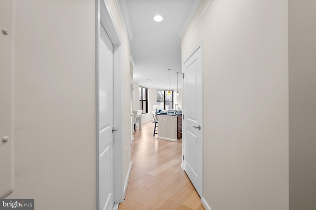 hall with ornamental molding, recessed lighting, and light wood-style flooring