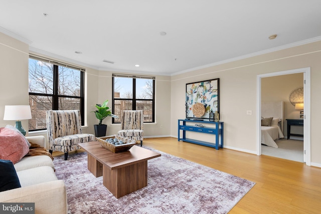 living room with light wood-type flooring, baseboards, crown molding, and recessed lighting