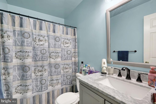 full bath featuring a shower with shower curtain, vanity, and toilet