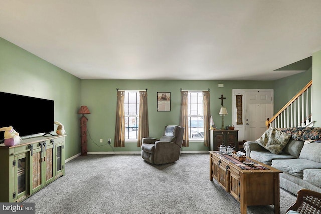 living area with carpet floors, stairs, and baseboards