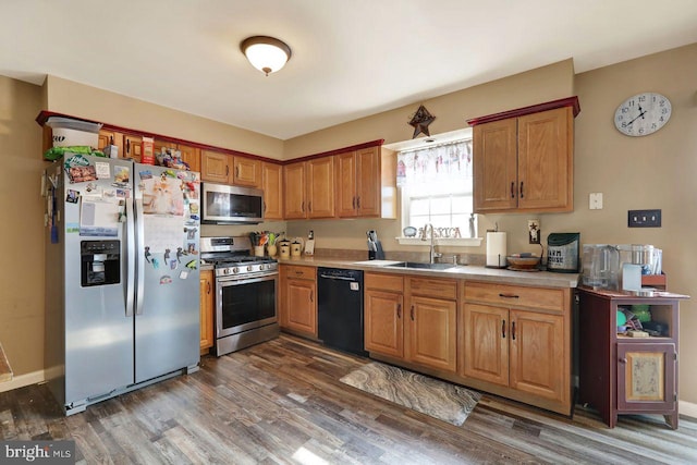 kitchen with stainless steel appliances, brown cabinets, light countertops, and a sink