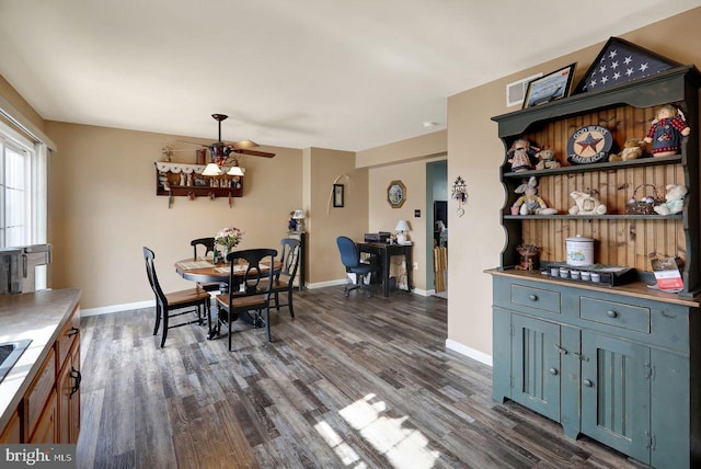 dining area with ceiling fan, baseboards, and dark wood finished floors