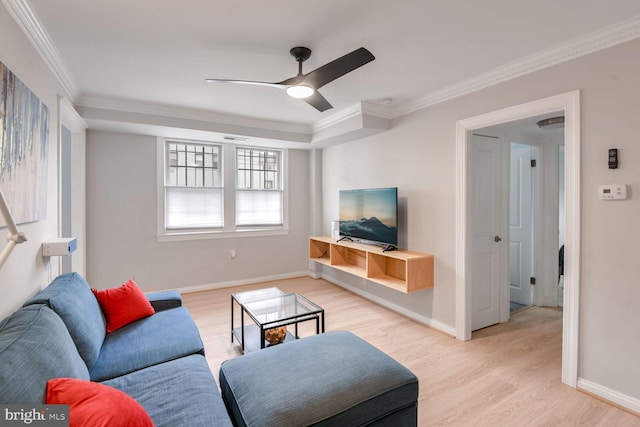 living room featuring baseboards, crown molding, and light wood finished floors