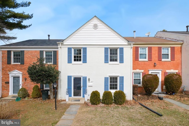 multi unit property featuring entry steps, a front lawn, and brick siding