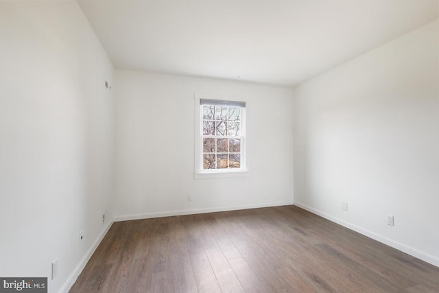 unfurnished room with baseboards and wood finished floors