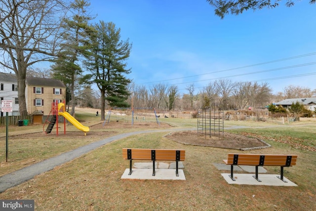 view of home's community featuring playground community and a yard