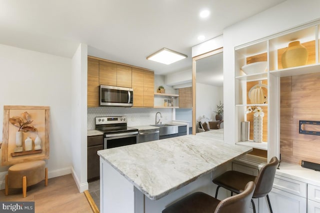 kitchen with a kitchen breakfast bar, appliances with stainless steel finishes, decorative backsplash, open shelves, and modern cabinets