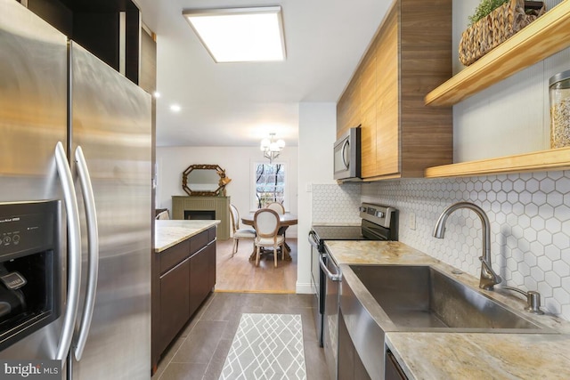 kitchen with stainless steel appliances, open shelves, light countertops, and decorative backsplash