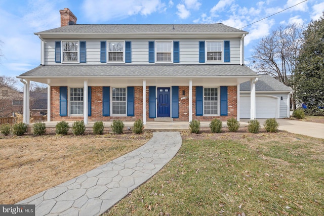 view of front of home featuring brick siding, a chimney, a shingled roof, covered porch, and a front yard