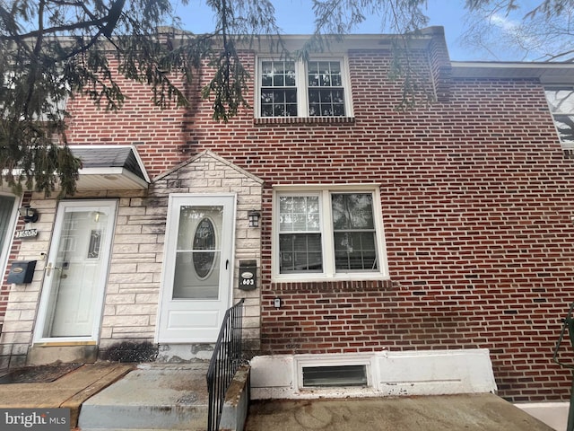 townhome / multi-family property with stone siding and brick siding