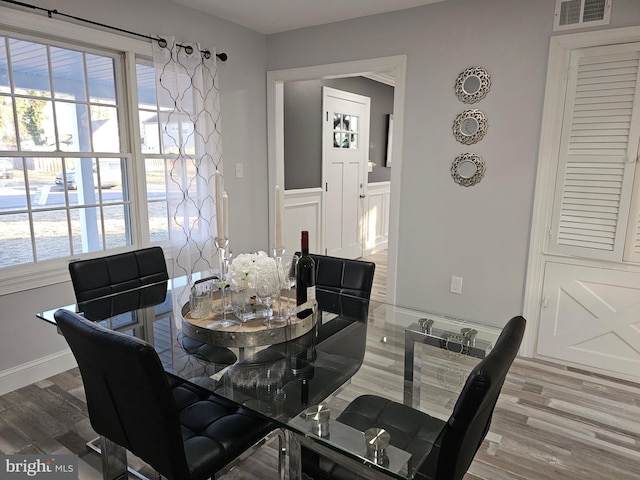 dining space featuring a wealth of natural light, visible vents, and wood finished floors