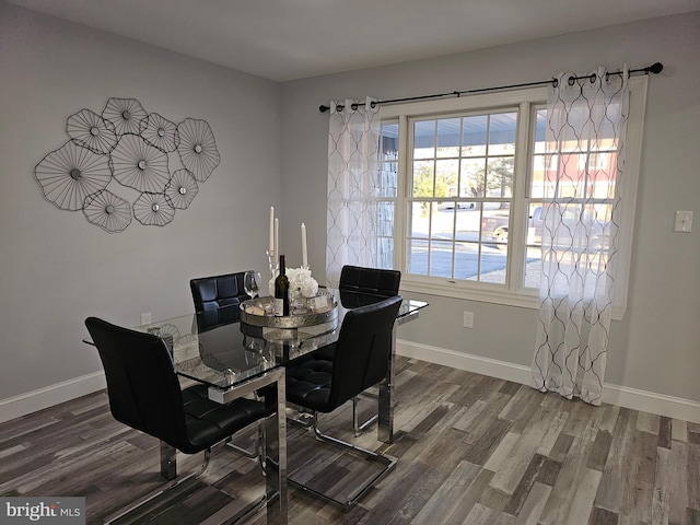 dining area with baseboards and wood finished floors