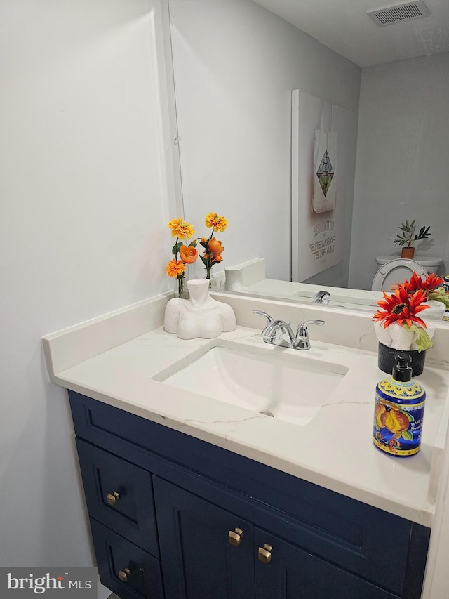 bathroom featuring visible vents, vanity, and toilet