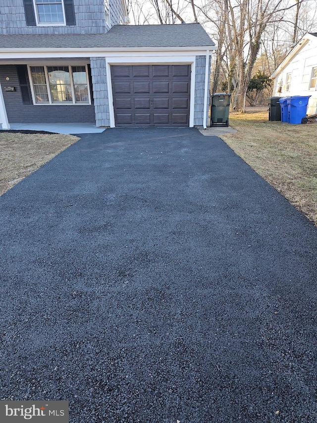 garage with aphalt driveway and a porch