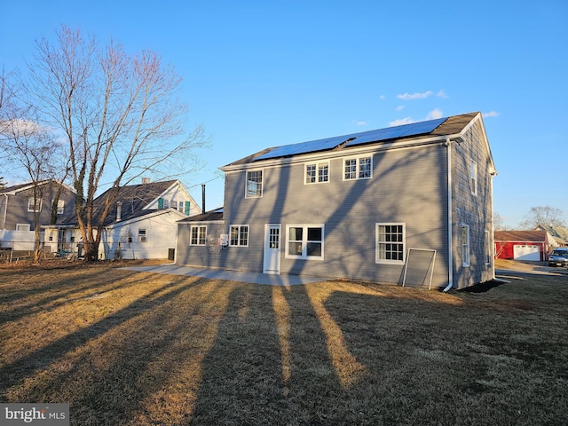back of house featuring solar panels, a residential view, fence, a yard, and a patio area