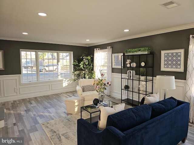 living room featuring recessed lighting, visible vents, ornamental molding, wainscoting, and light wood finished floors