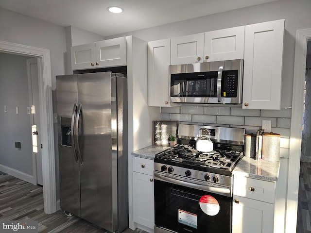 kitchen featuring appliances with stainless steel finishes, white cabinets, and light stone counters