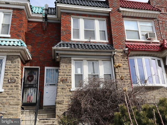 view of property with entry steps and a tile roof