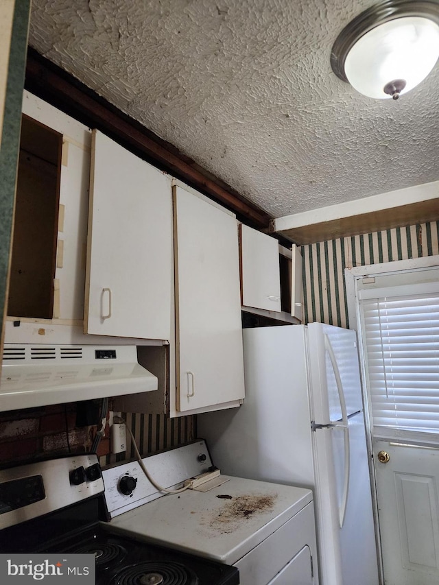 kitchen featuring washer / clothes dryer, stainless steel range with electric stovetop, light countertops, under cabinet range hood, and white cabinetry