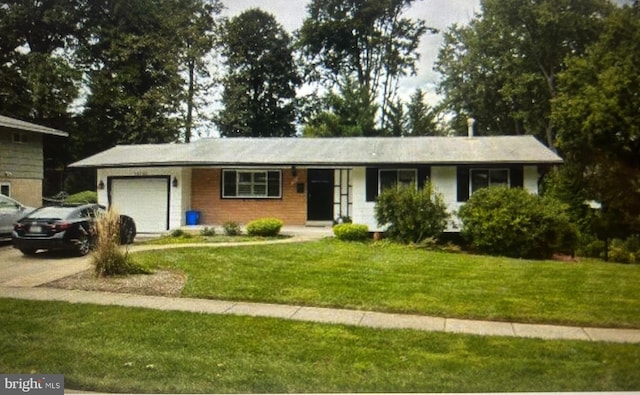 single story home featuring an attached garage, concrete driveway, and a front yard