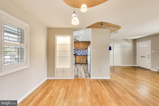 interior space featuring light wood-type flooring and baseboards