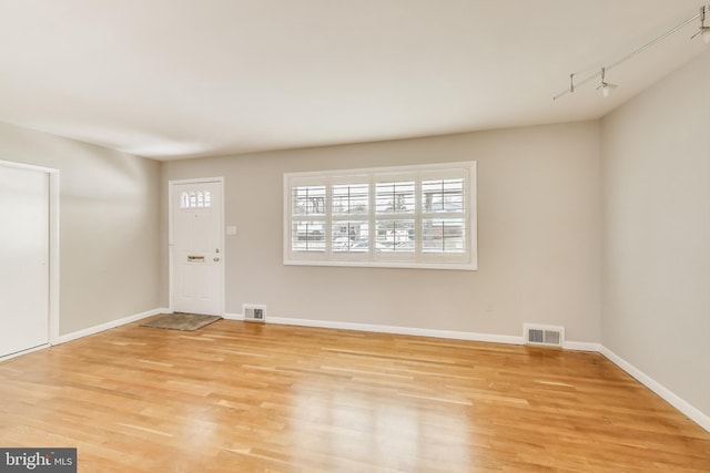 entryway featuring light wood finished floors, visible vents, and baseboards