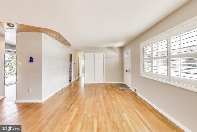 foyer featuring light wood-type flooring, visible vents, and baseboards