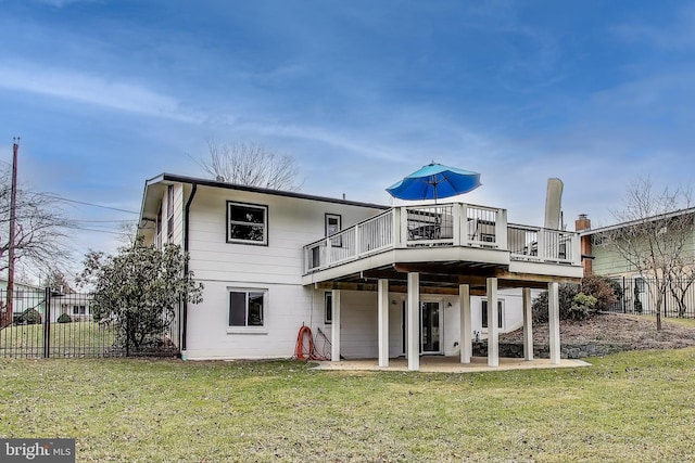 rear view of property with a deck, a yard, a patio area, and fence