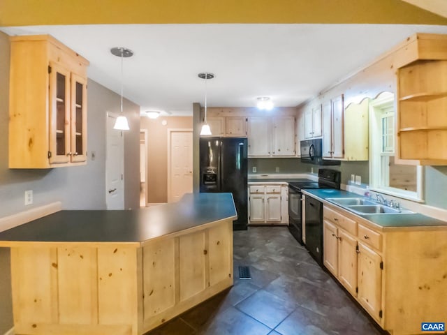 kitchen with dark countertops, glass insert cabinets, black appliances, pendant lighting, and a sink