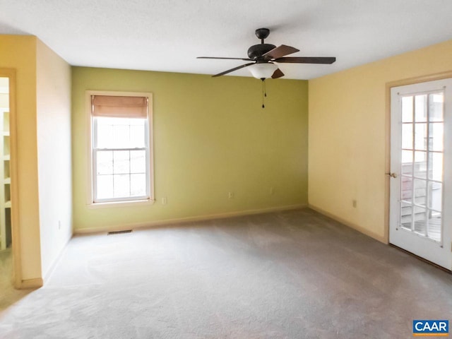 unfurnished room with a healthy amount of sunlight, light carpet, and visible vents