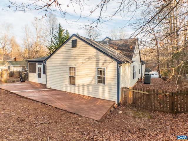 back of property featuring a deck, cooling unit, and fence