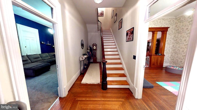 stairs with parquet flooring, baseboards, and wallpapered walls