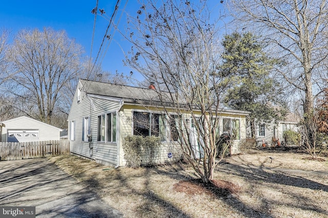 view of front of property with a garage, driveway, a chimney, and fence