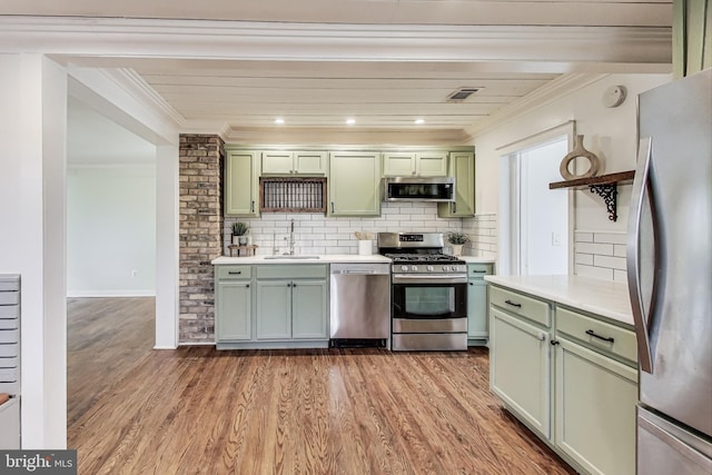 kitchen featuring visible vents, green cabinets, appliances with stainless steel finishes, a sink, and light wood-type flooring