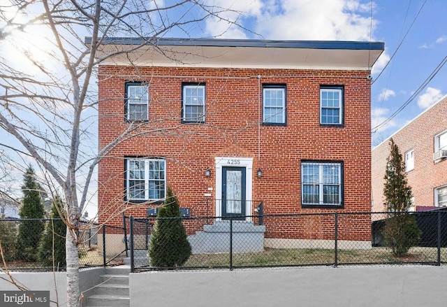 view of front of home featuring a fenced front yard and brick siding