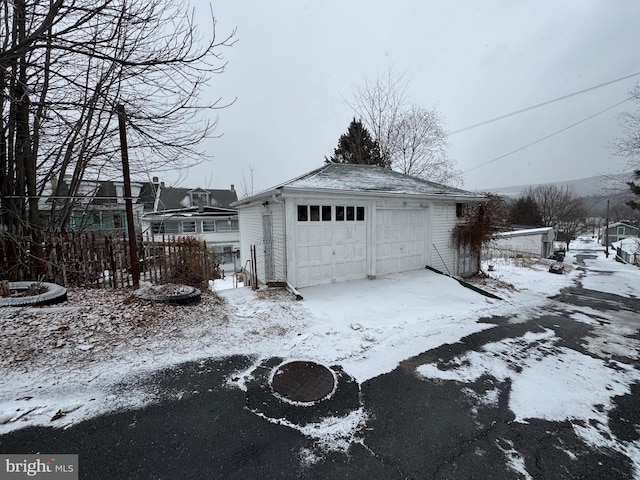 snow covered garage featuring a detached garage