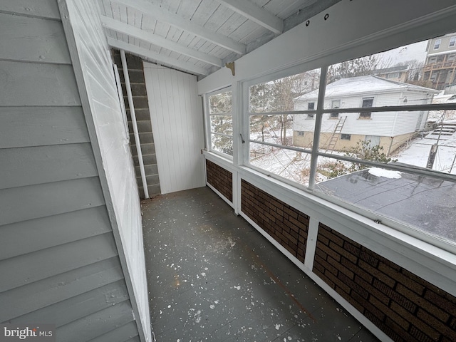 unfurnished sunroom with lofted ceiling with beams and wooden ceiling