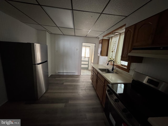 kitchen with dark wood finished floors, stainless steel appliances, light countertops, a sink, and a drop ceiling