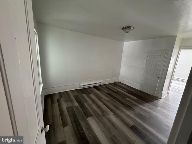 unfurnished bedroom featuring dark wood-style flooring, a baseboard radiator, and baseboards