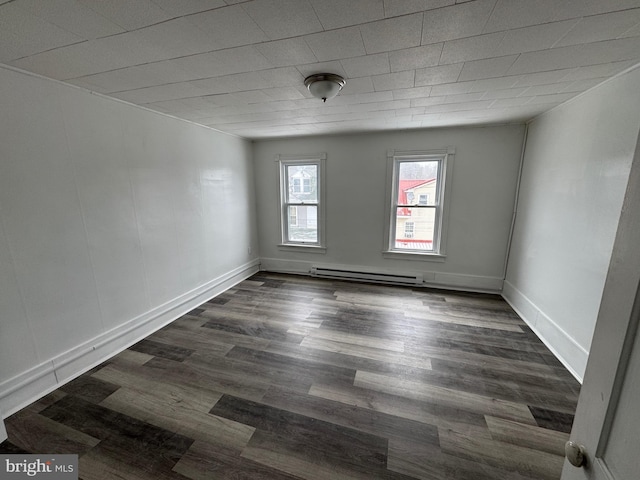 empty room with a baseboard radiator, dark wood-style flooring, and baseboards