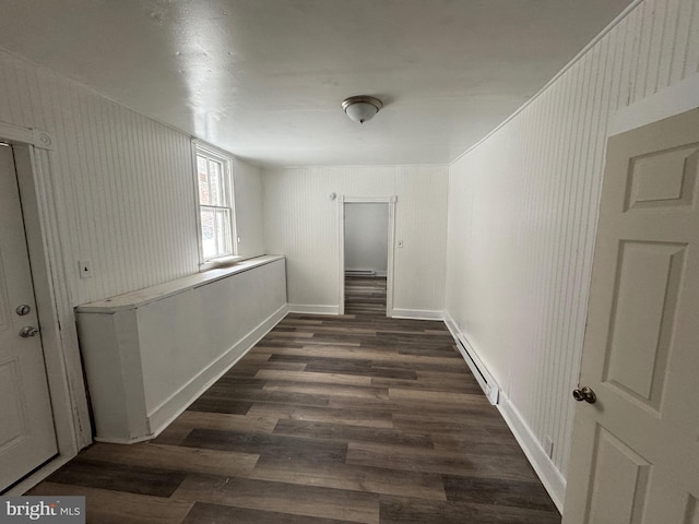 corridor with dark wood-style floors, a baseboard heating unit, and baseboards