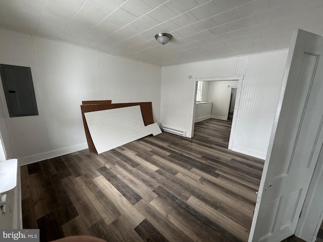 empty room with dark wood-style floors, a baseboard radiator, electric panel, and baseboards