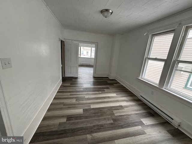 interior space with crown molding, baseboards, baseboard heating, and dark wood finished floors