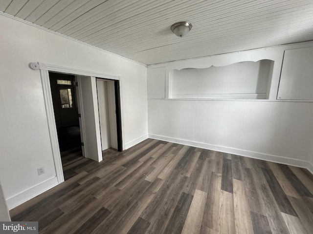 unfurnished room featuring dark wood-style floors and baseboards