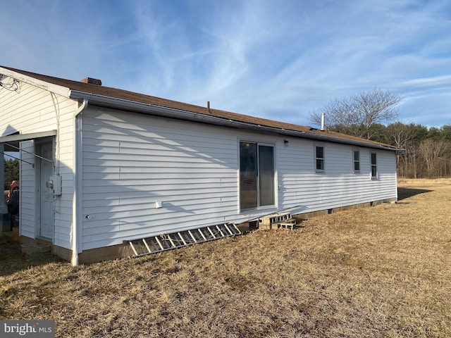 rear view of house featuring crawl space and a yard