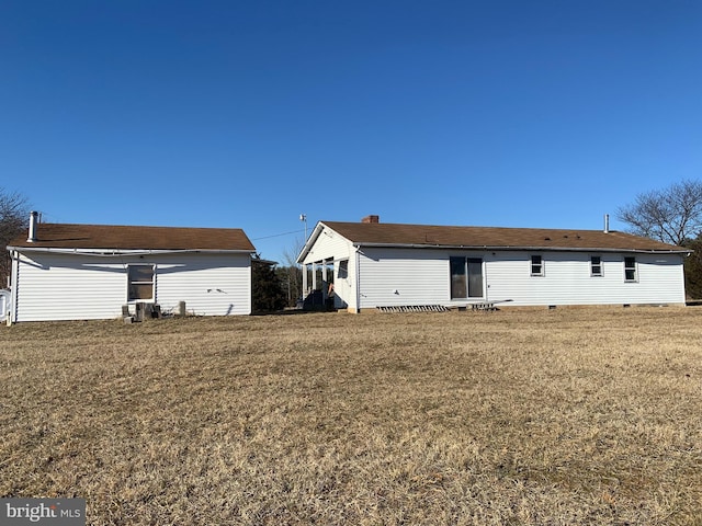 rear view of property with crawl space and a yard