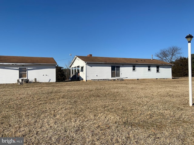 rear view of house featuring a yard