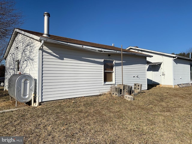 rear view of property featuring a yard and heating fuel