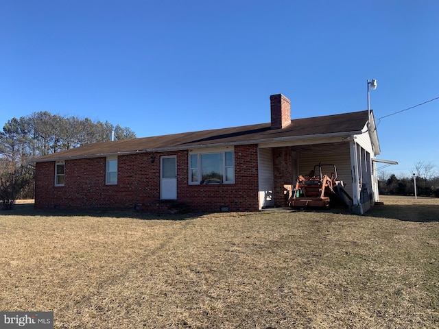 view of front of property featuring a front yard, a chimney, and brick siding