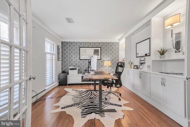 office featuring wallpapered walls, visible vents, light wood-style flooring, an accent wall, and baseboard heating